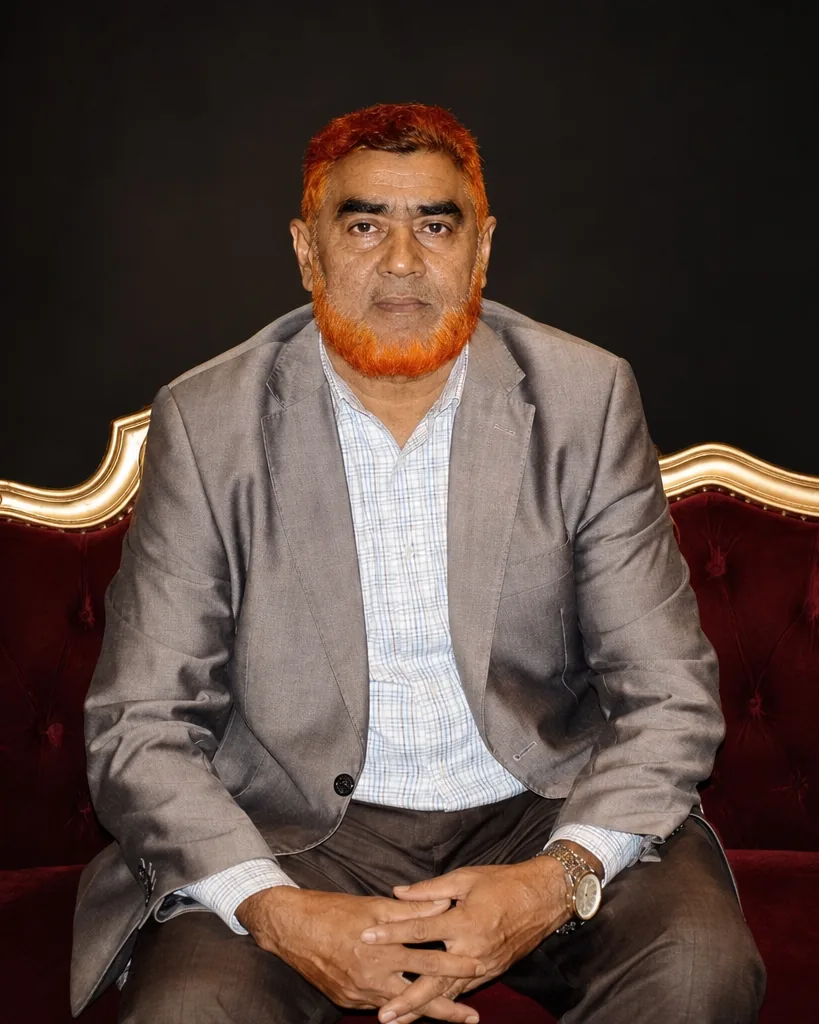 Abul Kalam Bhuiyan, Managing Director of Heaven Furniture Mart, seated on a hand-carved settee upholstered in oxblood velvet